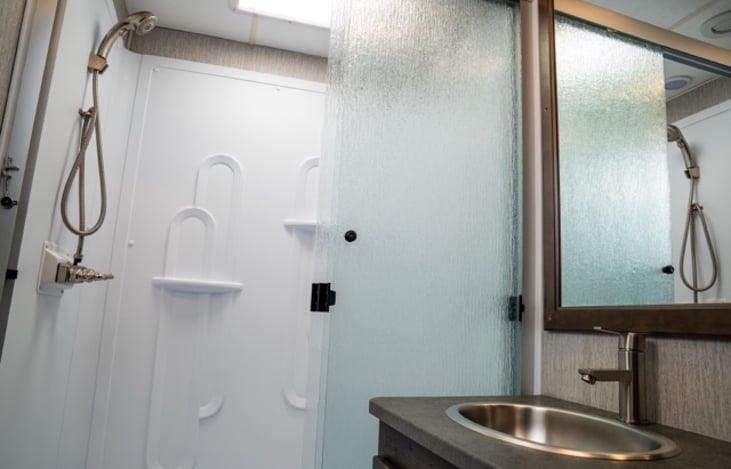 residential style shower with sliding glass doors.