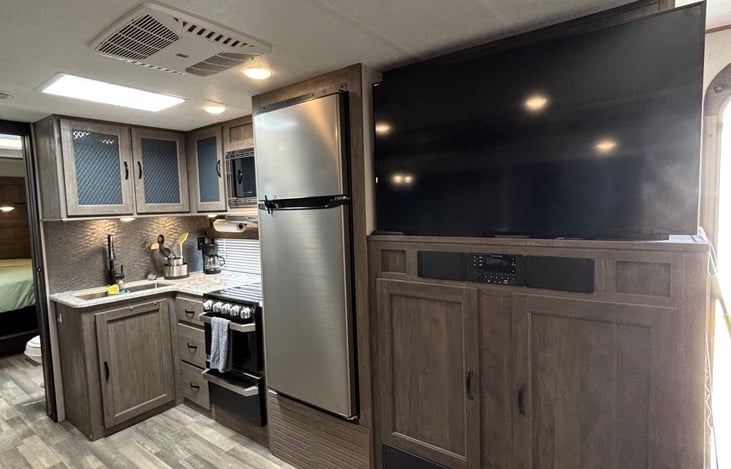 View of kitchen and large 55" inch TV for family movie nights and rainy day entertainment