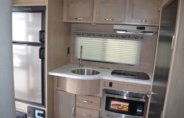 Kitchen has a stove and convectional microwave