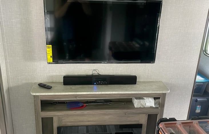 Media center with Smart TV, sound bar for indoor and outdoor sound system, and electric fireplace.