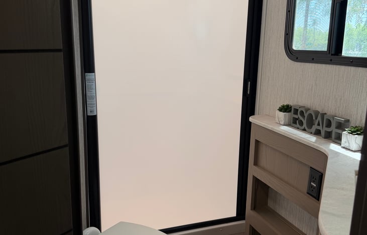 Bathroom Shower has a pull across enclosure.