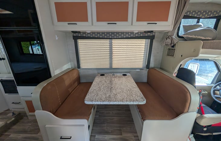 Bright, modern interior with a cute pop of color! Features a cozy rear queen bed, fully equipped kitchen, converting dinette, over-cab bunk, and an accent armchair. Clean, open, and ready for adventur