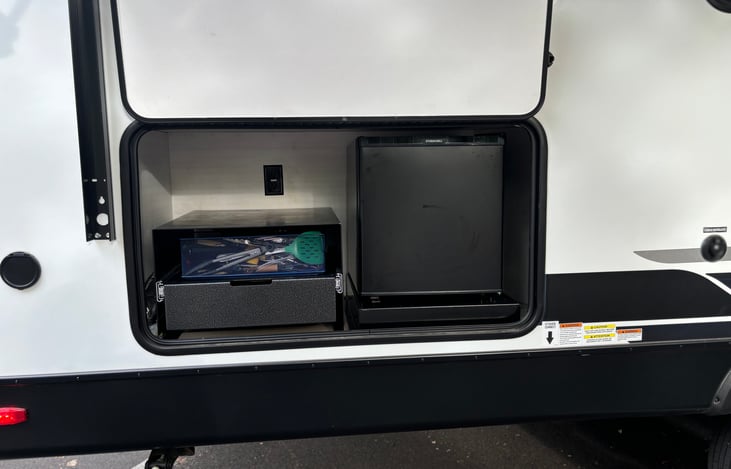 Outdoor cooking area to include small fridge and pullout grill space. 22" Blackstone flat grill for cooking is included.