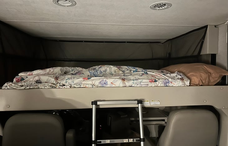 Drop down bed over driver's seat holds 500 lbs.  plenty of head room you should not feel stuffy