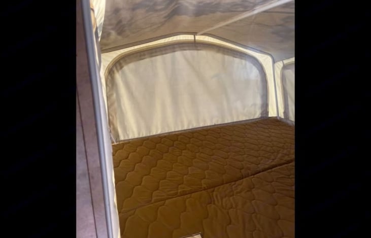 This is inside the rear pop out, there are zippers to allow natural airflow. 
you can sleep in this space or use it for more storage