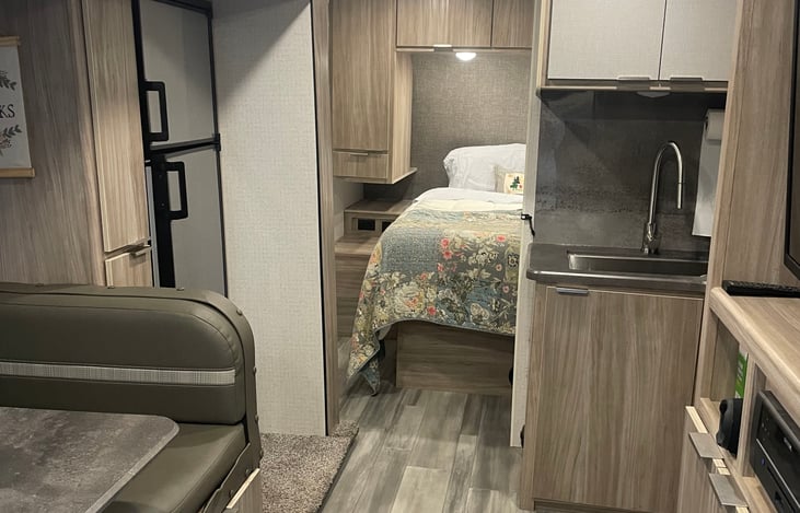 Kitchen looking into the main bedroom with queen bed. Bedroom has a sliding door for added privacy.