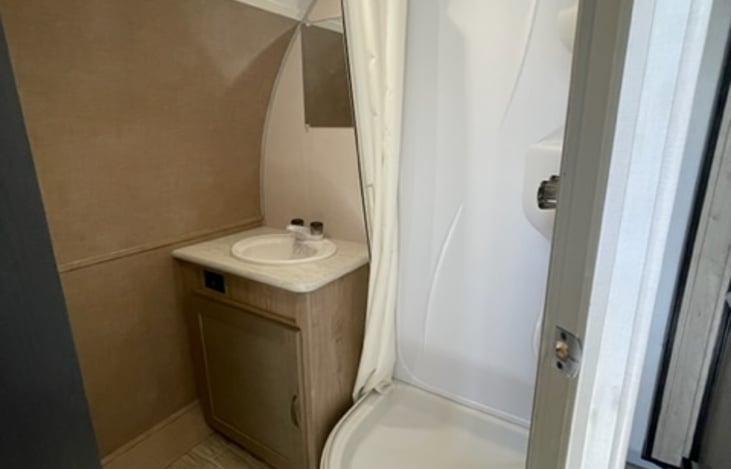 Step into the shower, utilize the storage cabinets, and appreciate the thoughtful details that make this bathroom a true retreat. The travel trailer's bathroom combines functionality with comfort.