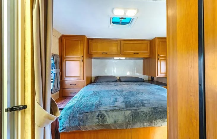 Cozy queen bedroom in the Thor Majestic 28A — a quiet retreat after long road trips or late festival nights. Perfect comfort for couples or families on their Las Vegas RV rental adventure.
