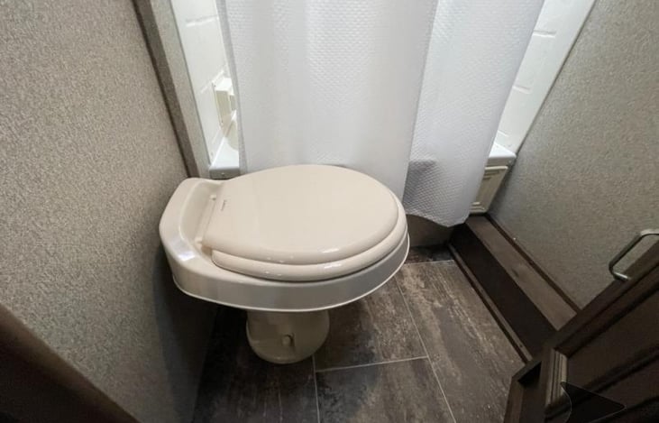 Back bathroom toilet with foot flush.
