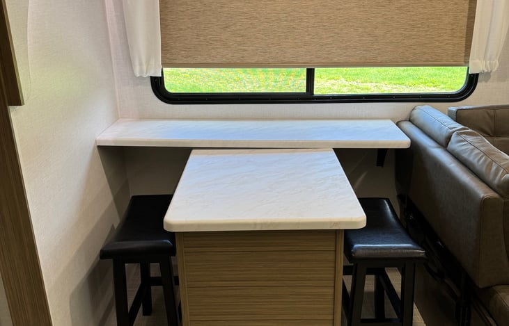 Dinning area with versatile dinette and two stools.
