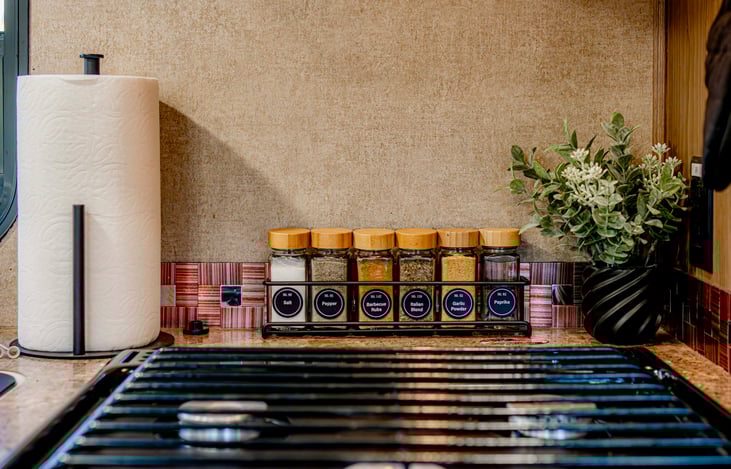 Spice rack with everyday essentials; salt, pepper, barbecue rub, Italian blend, garlic powder, and paprika.