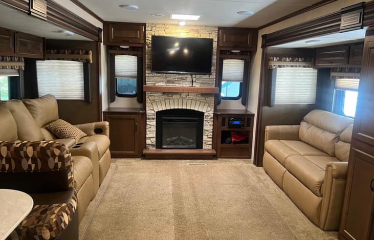 Opposing slide open this very spacious living room. Couch fold to a bed and love seat features reclining chairs.