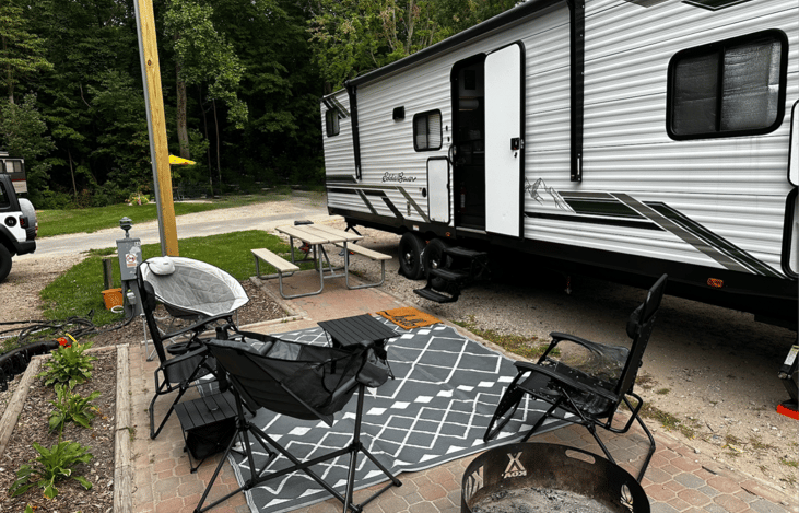 Two outdoor chairs and rug provided along with the outdoor griddle and mini fridge.