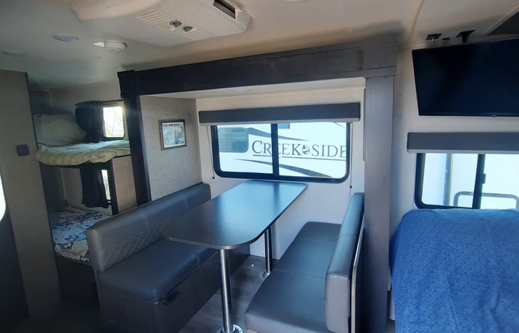 Slide out with convertible table to bed, queen bed with tv, and bunkbeds.