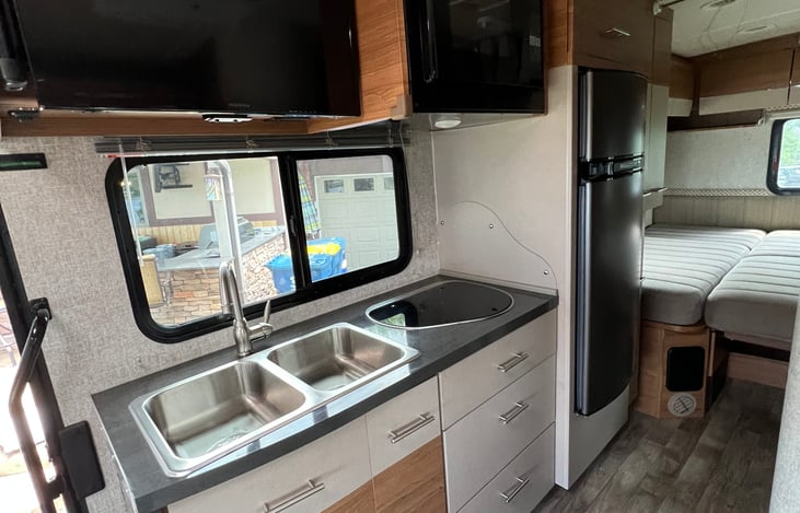Kitchen area with microwave, stove, sinks, storage, fridge and freezer