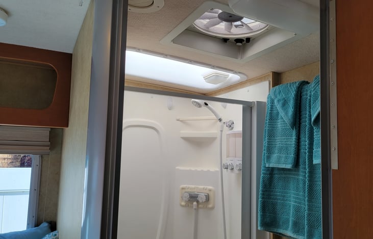 Notice the fantastic fan for unbelievable air circulation of motorhome.  Color cordinated towels/bath rug. Dove soap dispenser with Pantine shampoo/conditioner. Skylight for extra height/light