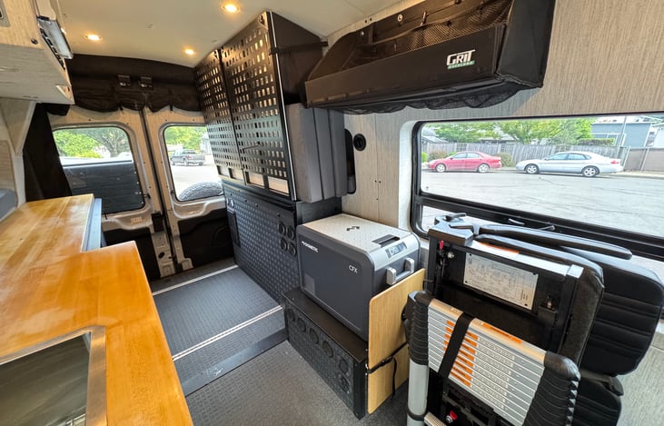 Rear blackout windows offer full privacy with a clear view out. Fold-up seats add space, ladder straps on, swivel table tucks by the CFX3 45 fridge, and the Murphy bed stores flat for roominess.