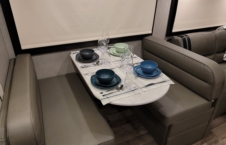 Dining area setup for 4. Extra storage under seats.  Dining table also converts into sleeping space/daybed with extra cushion.