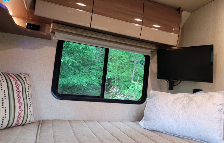 Back bedroom TV and wraparound overhead storage cabinets.
