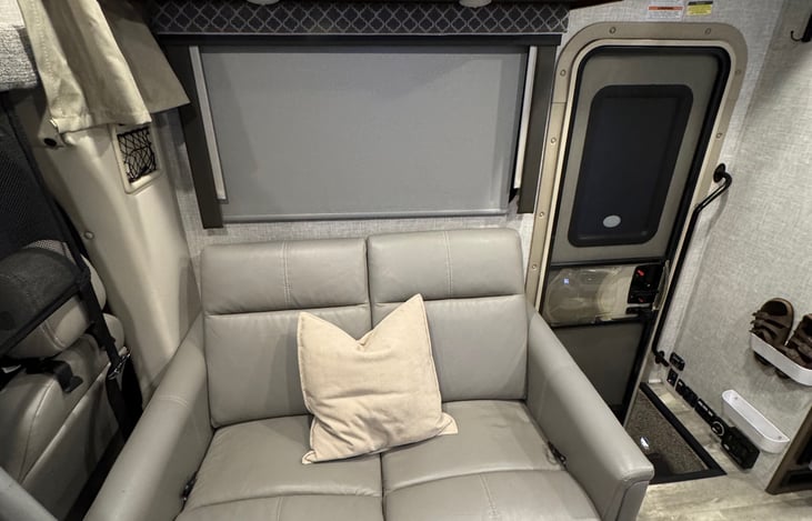 Entry door located next to the loveseat, shoe storage on wall by the stairs. Large operable window with manual room darkening shades. Power outlets on bottom of cabinet, USB outlets on wall.