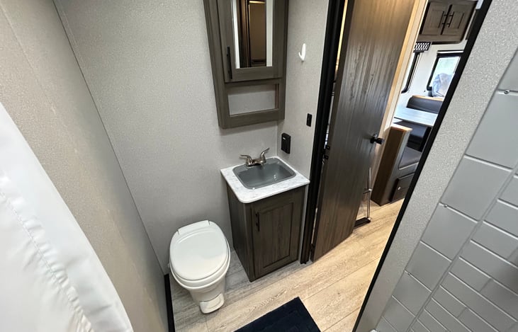 Bathroom includes sink and storage for toiletries.
