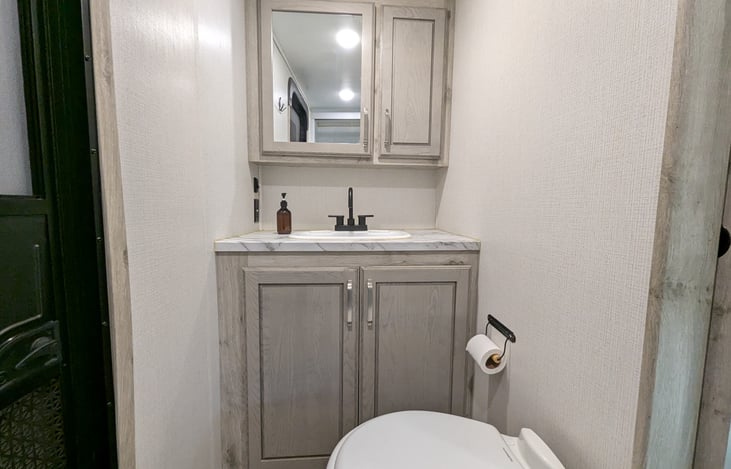 Privacy and convenience! This second full bath features a walk-in shower, porcelain toilet, and its own exterior entrance—perfect for quick access without tracking dirt through the whole rig.