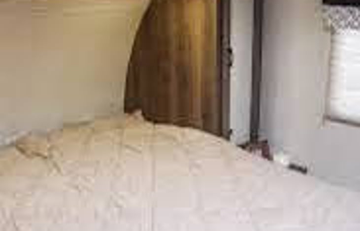 queen sized bed in bedroom with doors and closets on each side