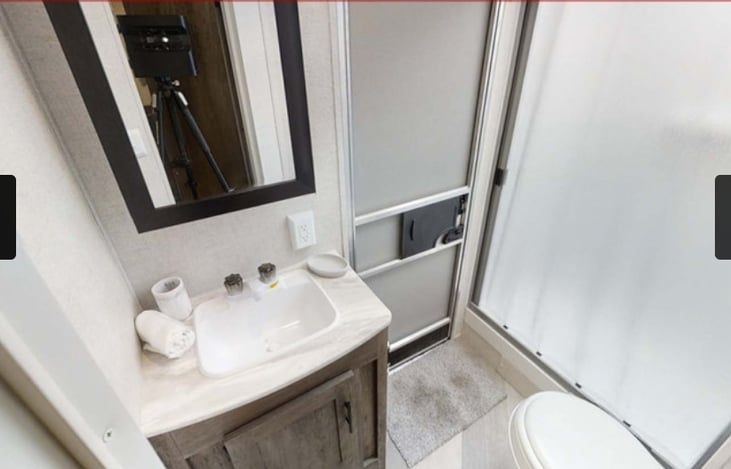 Bathroom with stand up shower and a separate entrance for the convenience of not having people walking thru the camper just to use the restroom