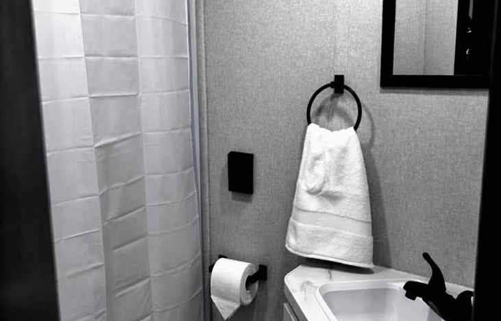 Clean, private bathroom with a shower, sink, and fresh towels—everything you need for comfort on the road.