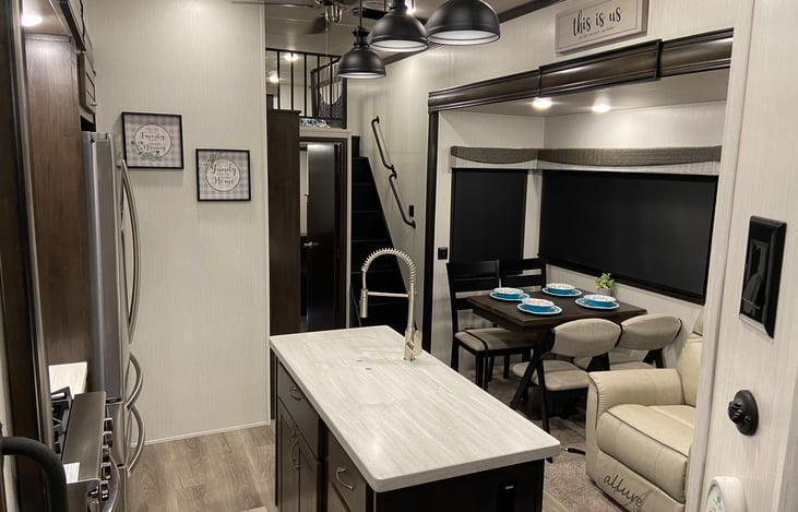 View towards the rear of the camper toward the loft equipped with 2 bunk mattresses, a pantry next to the kitchen and the rear bedroom / lounge area.