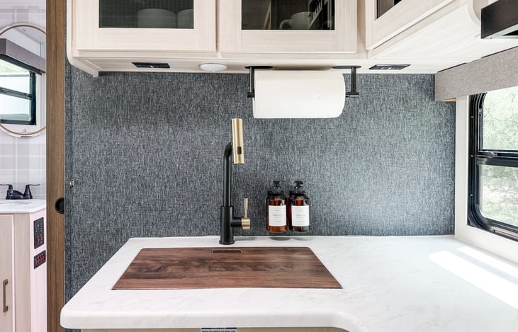 Wood cutting board fits over sink for extra counter space.