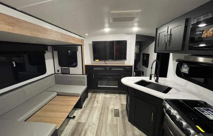 Interior space with table in down position for additional sleeping space. Electric fire place for heat/ ambient background. tv with antenna, HDMI inputs.