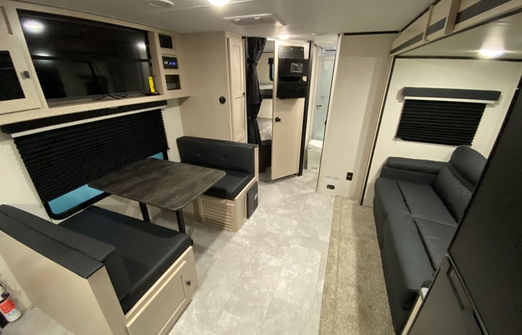 Front to rear view of living and dining areas with bunkroom and bathroom in rear