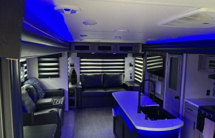 This is looking to the rear of the camper. couch and loveseat. Window blinds are all closed. The couch pulls out to make a bed.