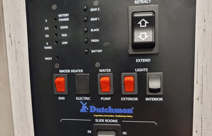 Control panel where you can check on the status of the tanks, turn on/off the water pump and water heater, turn on/off the exterior and interior lights as well as control the awning and slider.