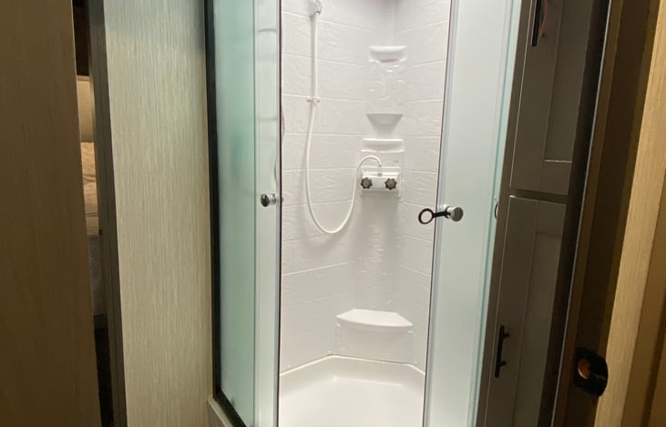 The stand up shower in the full bath located in the middle of the trailer.