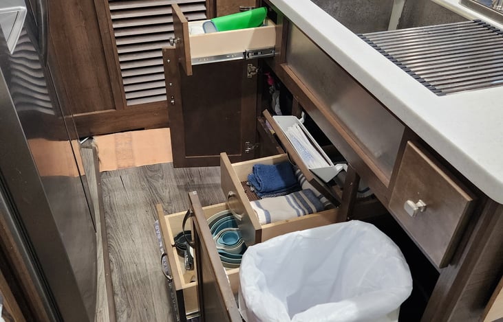 Kitchen storage and trash bin.