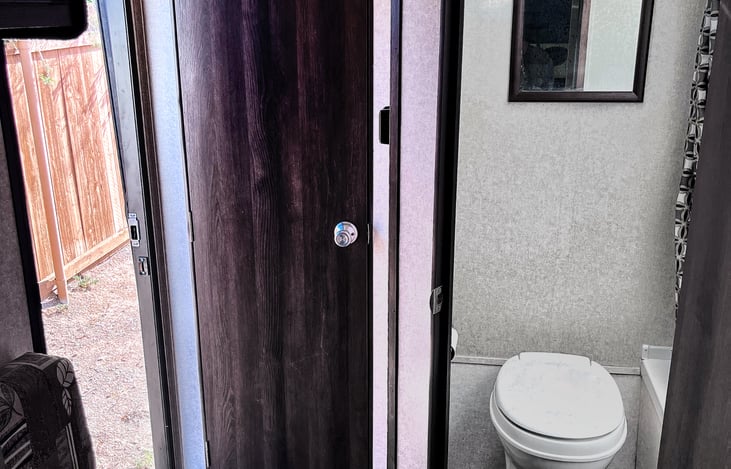 Bathroom has a shower/tub (to the right of the toilet) and a skylight.