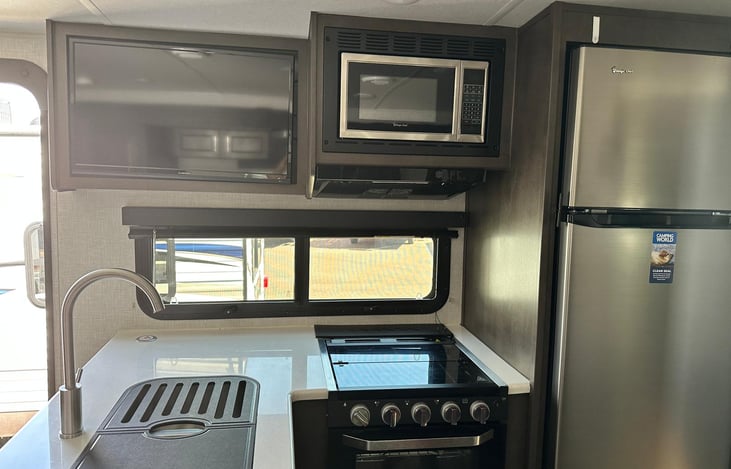 Inside Kitchen with full size fridge and freezer, TV, Microwave, Gas Stowe and Oven, Double Sink and extention