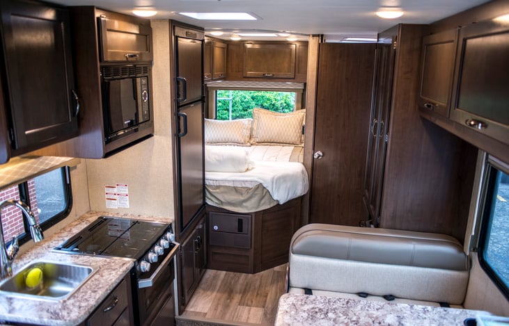 Spacious kitchen include cooking equipment, utensils, glassware, plates, cleaning supplies.