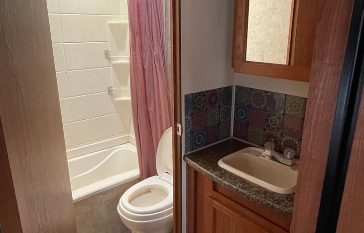 Bathroom area.
Toilet & shower inside / vanity sink outside