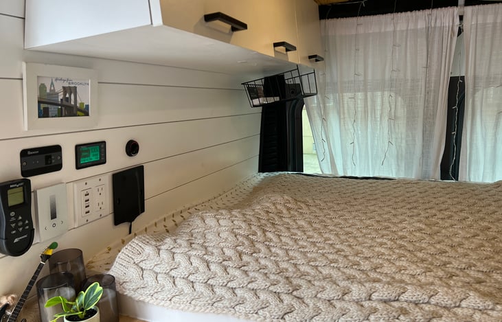 View of bed area with three storage cabinets.