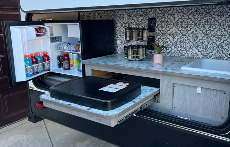 Outdoor kitchen with grill, sink and fridge/freezer