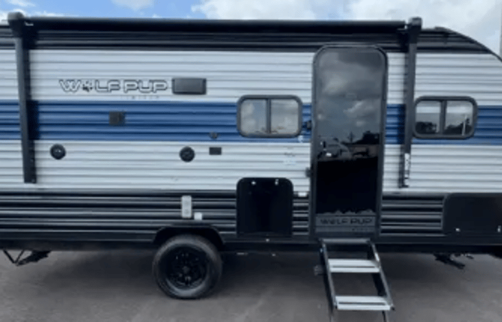 The camper includes an outdoor refrigerator, a lighted electric awning, an outdoor shower, and a TV bracket to watch TV outdoors.