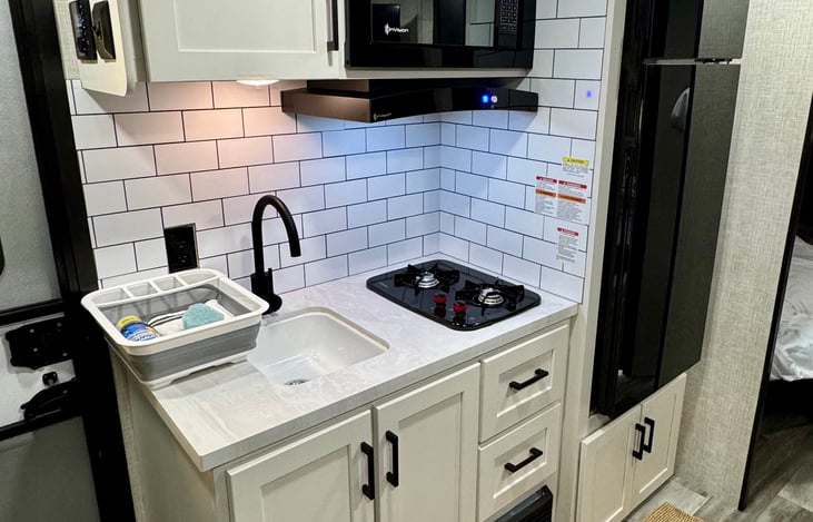 Fully equipped and ready for any meal! This modern kitchen features a gas range, microwave, and full-size fridge, plus all the cookware, dishes, and wine glasses you need.