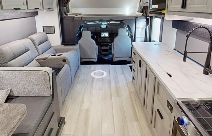 Queen Bed over cab.  *photo similar - futon couch in lieu of bucket seats in our RV.