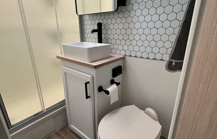 Bathroom with shower, stocked with towels.