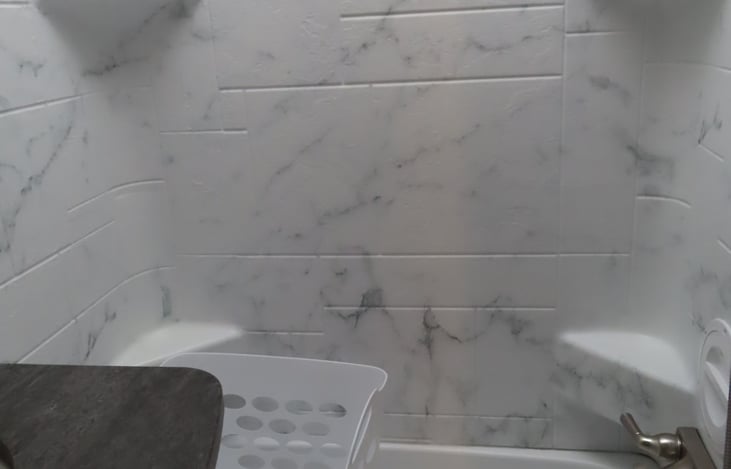 Spacious shower/bathtub combo and includes a dirty clothes hamper for your convenience.