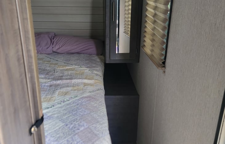 Front master bedroom with night stands, usb, and charging outlets, overhead, and closet storage on each side. Sliding doors for privacy.