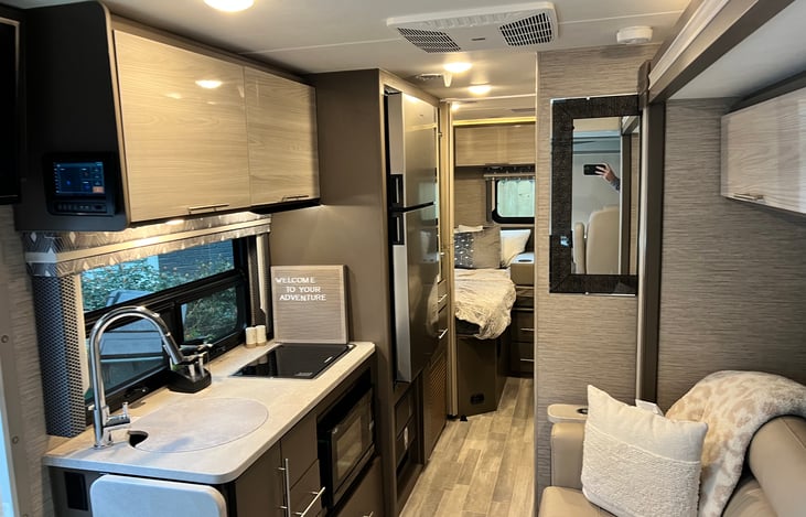 Great kitchen area with convection microwave, 12v spacious refrigerator, and fully stocked with plates and cookware. Right next to the kitchen is a couch that turns into a full bed.